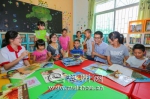 支教老师在图书阅览室内与孩子们玩猜谜游戏。（吴腾江　摄） - Meizhou.Cn