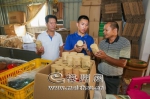 来纲（中）在了解重新设计包装后的茶叶销售情况。（吴腾江　摄） - Meizhou.Cn