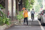 ↑环卫工人在梅江一路清理绿化带的落叶。 - Meizhou.Cn