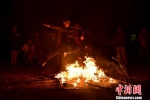 壮家汉子从燃烧的火堆上跳过去。　连清 摄 - 中国新闻社广东分社主办