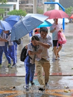 ▲客都小学门口，家长冒着风雨接孩子。（高讯　摄） - Meizhou.Cn