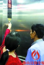 11月2日，业主在东海银湾10座按电梯警铃，听不到监控室应答声。/佛山日报记者梁建荣摄 - 新浪广东