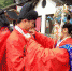 50个民族70对情侣“单身节”在广东东莞凤岗镇举行多民族特色集体婚礼。图为身穿民族特色服装的新人们在台下互相帮忙整理服装。　安致标 摄 - 新浪广东