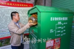 市民将旧衣物送进回收箱。（吴腾江　摄） - Meizhou.Cn