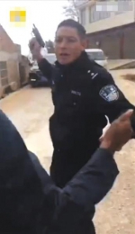 视频中显示，民警在持枪过程中被人拉扯，并有人高喊“抢不得”。视频截图 - Meizhou.Cn
