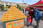 游客驻足观看展销会上展出的慈橙。 - Meizhou.Cn