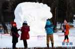 1在哈尔滨太阳岛雪博会园区，游客在雪雕前留影（12月9日摄）。 - News.Timedg.Com