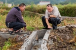 李建强（右）在检查灌溉水渠修建情况。（连志城　摄） - Meizhou.Cn