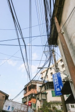 梅城江北的杨桃墩社区某楼旁私拉电线如蜘蛛网。（吴腾江　摄） - Meizhou.Cn