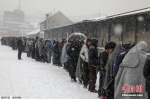 在大雪下，大批难民在贝尔格莱德一个货仓外排队，等候配给食物和其他救援物资。 - News.21cn.Com