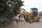 相关部门出动大型机械，对道路两侧的垃圾和违建物进行清理。（钟兴明　摄） - Meizhou.Cn