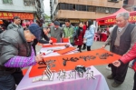 老年书法家现场挥春，为市民免费送春联。（连志城　摄） - Meizhou.Cn