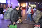 1月13日，旅客扛起行李准备登车。 中新网记者 金硕 摄 - News.Timedg.Com