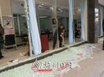柜台窗口的玻璃被击碎，工作人员在清理现场。 - Meizhou.Cn