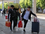 ←旅客手提肩扛带着年货踏上回家路。　（高讯　摄） - Meizhou.Cn