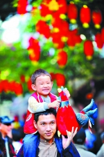 孩子抱着鸡公仔，父亲带孩子逛花市。 　　广州日报记者王燕 摄 - 新浪广东