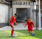 横陂镇第二小学校园内，两名小球员正进行对抗训练。 - Meizhou.Cn