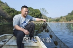 张英涛在查看淡水珍珠蚌生长情况。（林翔　摄） - Meizhou.Cn