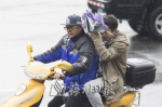 市民在寒风冷雨中骑车前行。 - Meizhou.Cn