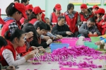 梅江区残联工作人员与嘉城义工成员教残疾人做假花。（吴腾江　摄） - Meizhou.Cn