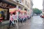 为缓解用血压力，义工们冒雨举牌倡议路人献血。（吴腾江　摄） - Meizhou.Cn