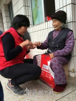 兴宁市小鱼义工协会义工在帮老人剪指甲。 - Meizhou.Cn