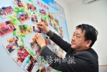 丘浩旋细心整理宣传栏内的义工活动照片。（钟小丰　摄） - Meizhou.Cn