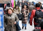 3月20日，受冷空气影响，新疆乌鲁木齐市降下纷纷扬扬的雪花，气温也随之骤降。图为民众冒雪出行。 中新社记者 刘新 摄 - News.21cn.Com