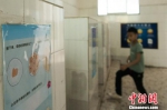 图为广西柳州文惠小学在男厕所悬挂的性知识绘本，让学生在排队上厕所，或蹲厕所时，抬头即能看见。　黄威铭 摄 - 广东电视网