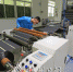 金华达公司技术人员在检查经涂布后制成的锂电池正极极片卷。（高讯　摄） - Meizhou.Cn