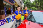 郑志争（左）与同伴为客户洗车。（吴腾江　摄） - Meizhou.Cn