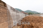修复后的护岸，钩机正在作最后的抛石护脚。(陈潮华 摄) - Meizhou.Cn