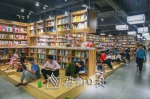 改造后的新华书店内保留少量的传统桌椅板凳，增设可以随意坐着阅读的“阶梯”。（吴腾江　摄） - Meizhou.Cn