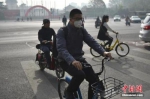 北京迎来沙尘天气市区能见度降低，市民佩戴口罩出行。 中新网记者 金硕 摄 - News.21cn.Com