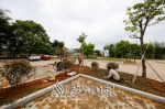 在三河镇汇城村，工人们正在对小公园进行绿化。 - Meizhou.Cn