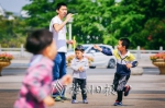 不少孩子在院士广场追逐、吹泡泡，玩得不亦乐乎。（连志城　摄） - Meizhou.Cn