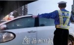 一位市民从车内副驾驶座向外拍下的照片：一名身穿制服和反光背心的交警正在指挥交通，浑身湿透。（李盛华翻拍） - Meizhou.Cn
