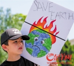 4月29日，在美国加利福尼亚州洛杉矶，一名儿童手持海报参加“人民气候游行”。 - News.Ycwb.Com