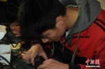 资料图：图为安徽省特殊教育中专学校一名学生正在维修手机。张子扬摄 - 新浪广东
