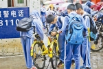 一群小学生放学后在校门口开锁使用共享单车。 - Southcn.Com
