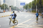 小学生在机动车道路上骑共享单车。 - Southcn.Com