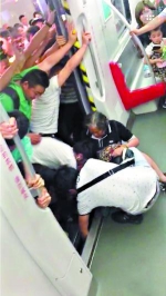 一名乘客在车厢里帮助女乘客把右腿拔出来。 - 新浪广东
