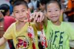 小朋友展示和家长一起制作的平安香囊。（连志城　摄） - Meizhou.Cn