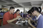 双胞胎姐妹考生胡冰、胡雪的父母到学校饭堂陪同就餐。 （林翔　摄） - Meizhou.Cn