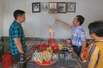 丘震伟（左一）的伯父向他介绍老屋内的祖先相片。（高讯　摄） - Meizhou.Cn