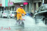 一市民骑车从积水处经过，溅起水花。 - 新浪广东