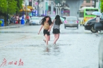 两名女子在小雨中涉水前行。 - 新浪广东