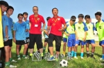 足球名宿钟云越（踢球者）、赖岳仁在梅南镇中心小学球场现场施教。（钟小丰　摄） - Meizhou.Cn