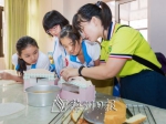 小朋友们和社工一起将做好的蛋糕分装进蛋糕盒。（连志城　摄） - Meizhou.Cn