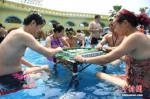 资料图：2017年8月2日，重庆洋人街一水上乐园举行夏季消暑活动，其中水中玩麻将吸引不少游客参与。陈超 摄 - 新浪广东